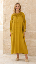 Full front view of model wearing mustard long-sleeve tiered maxi dress