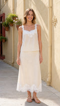 Front view of woman wearing cream pleated camisole and midi skirt set with lace trim