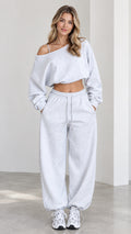 Front view of model wearing heather grey one-shoulder cropped sweatshirt and wide-leg sweatpants lounge set