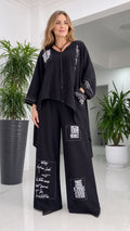 Front view of woman wearing black typography print two-piece pant set