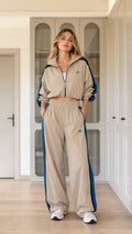 Model wearing khaki tan cropped windbreaker jacket and wide-leg track pants set front view