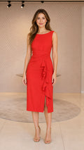 Full front view of a woman wearing a red ruffled midi dress and gold heels