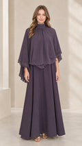 Front view of woman wearing dusty plum mock neck capelet maxi dress