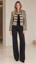 Front view of model wearing Beige Leopard cropped military jacket with dark wide-leg jeans