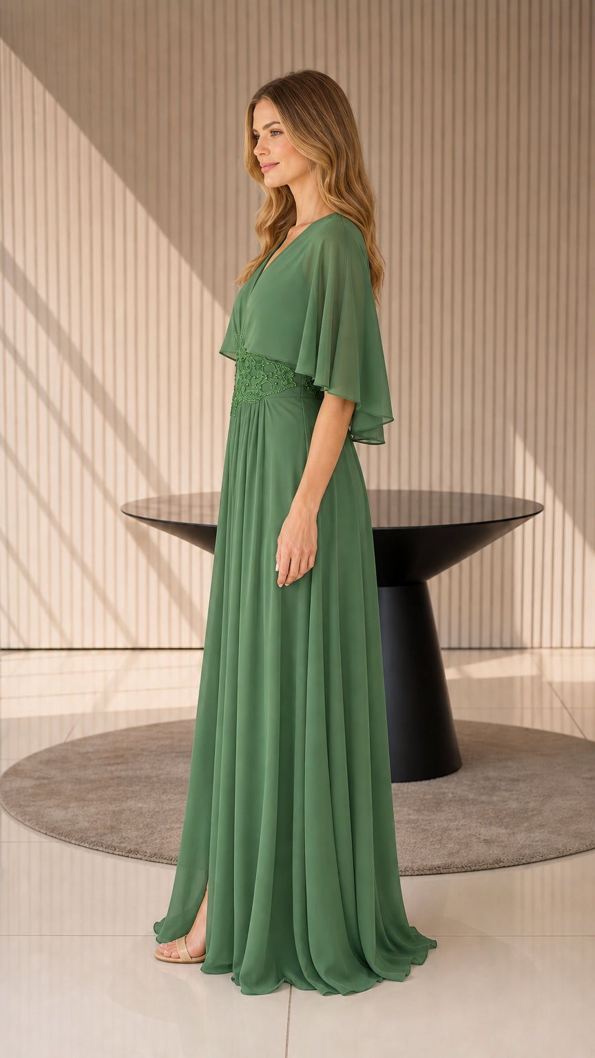Side profile of model in sage green evening dress showing flowing silhouette