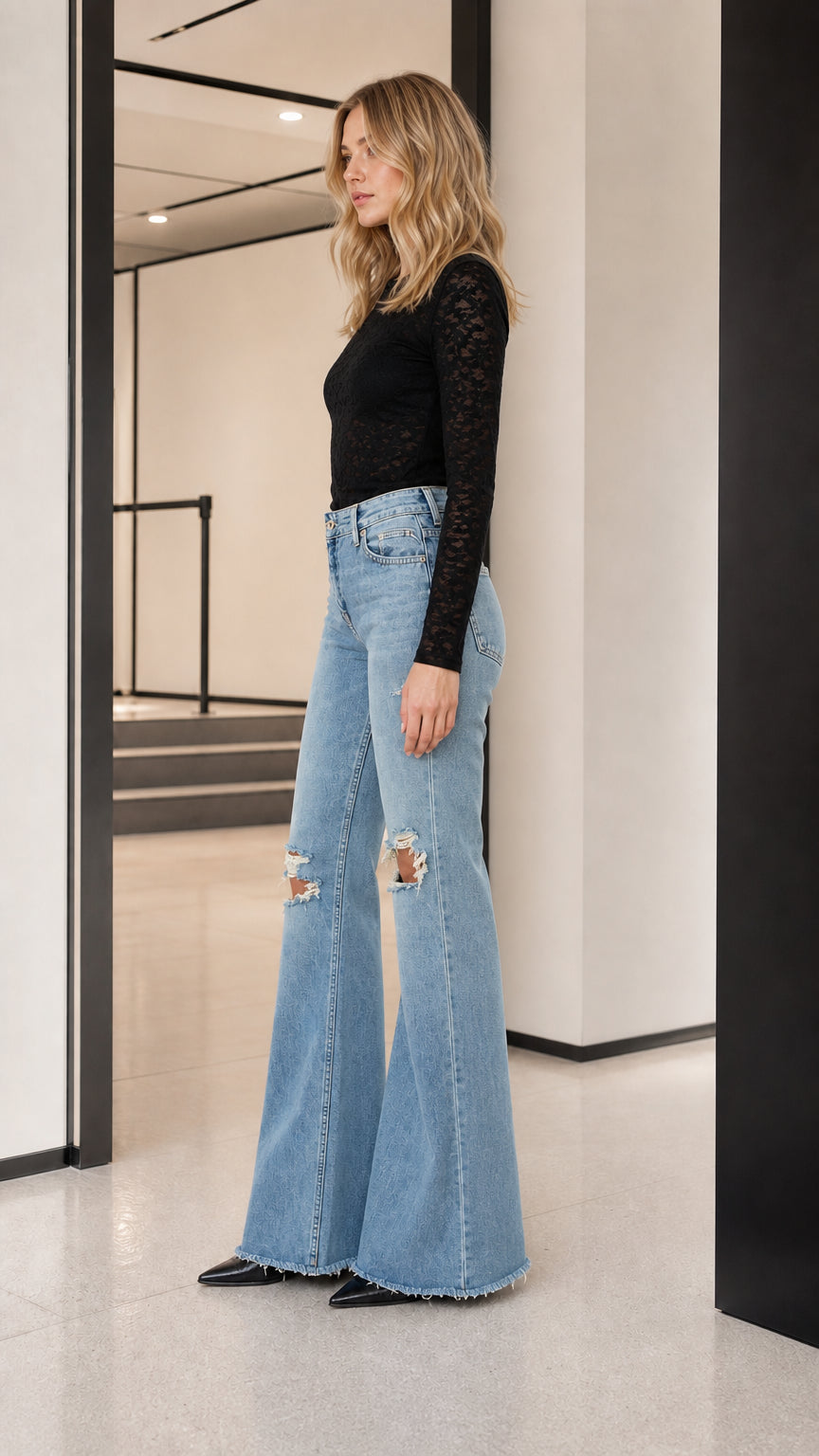Model wearing black long-sleeve sheer lace top, side profile view