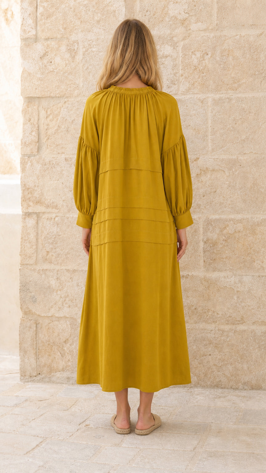 Full back view of model in mustard tiered maxi dress