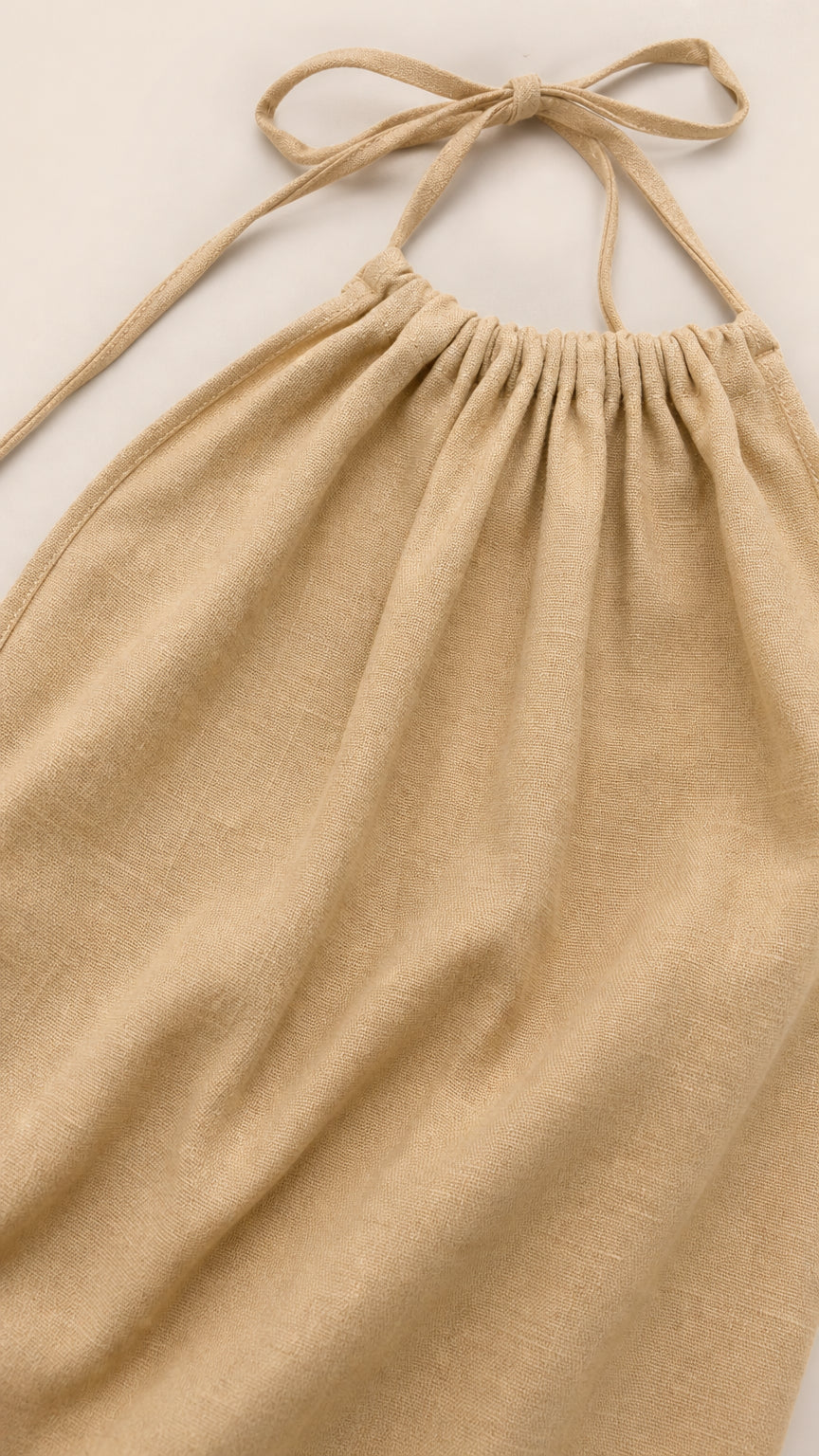 Close-up detail of gathered halter neckline and tie straps