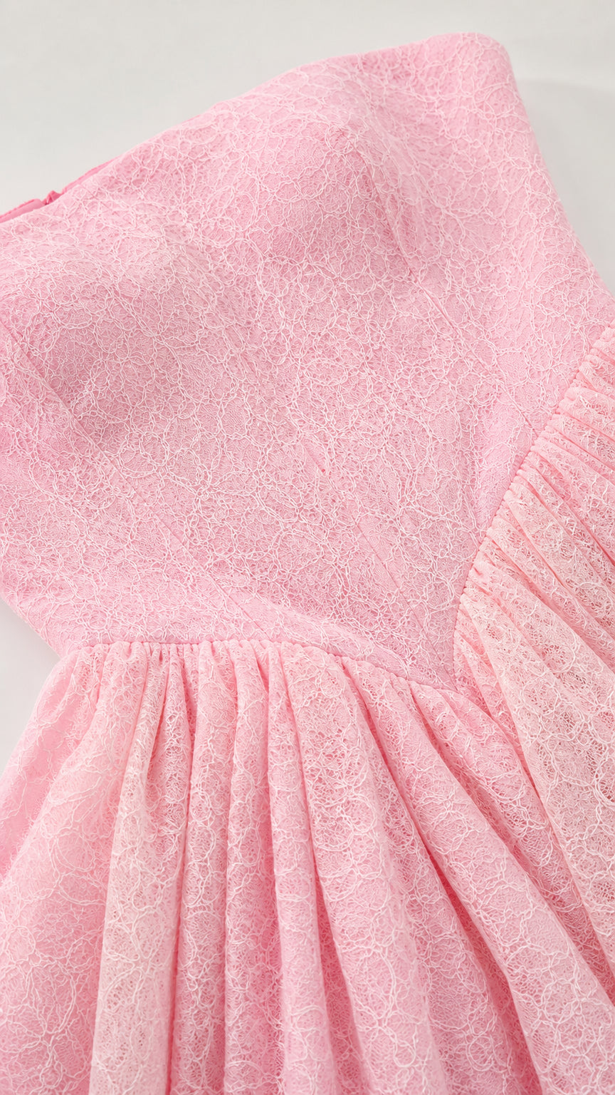 Close-up texture of delicate pink floral lace fabric and basque waist seam