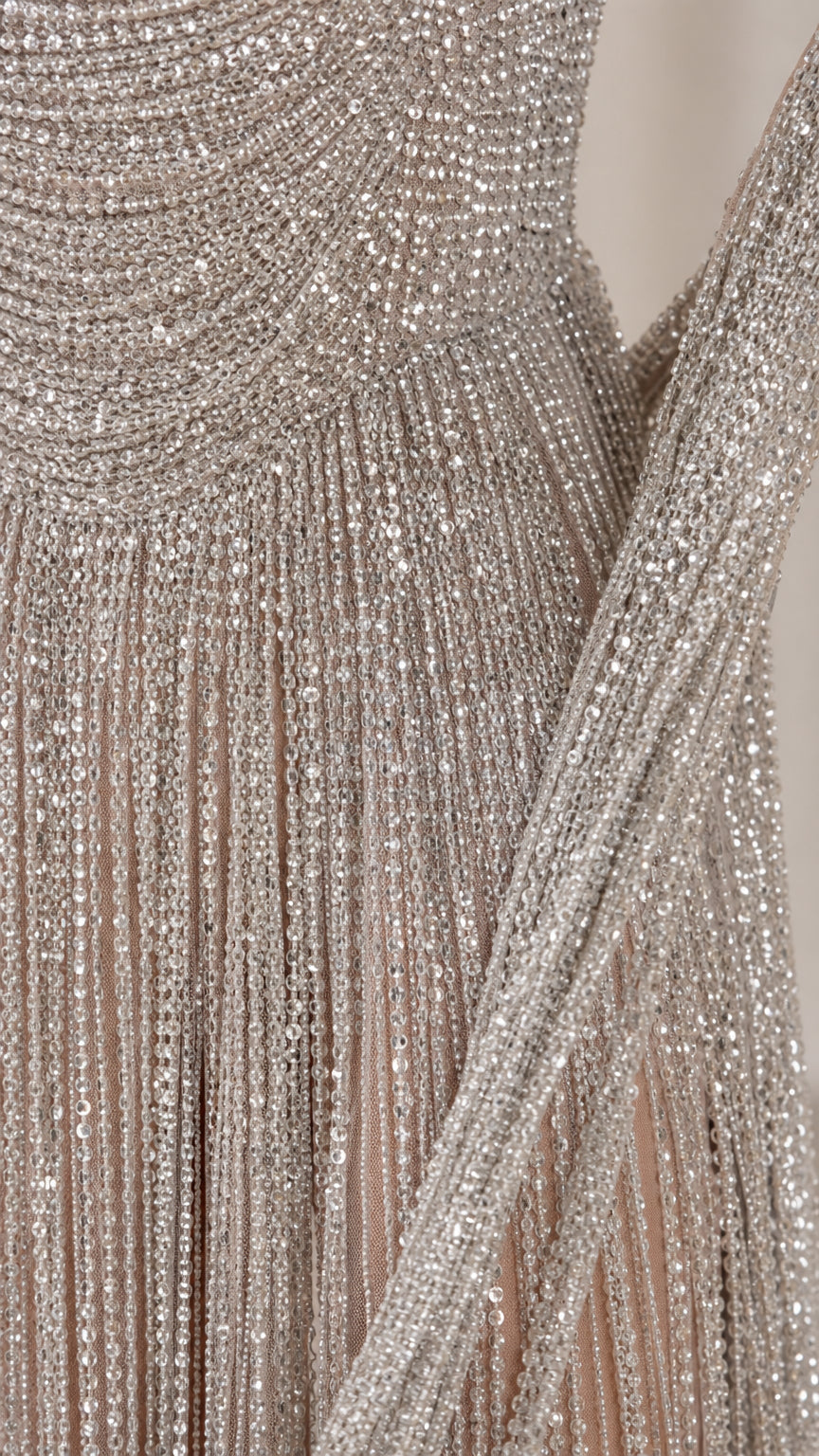 Close-up detail of silver beaded fringe embellishments and textured bodice craftsmanship