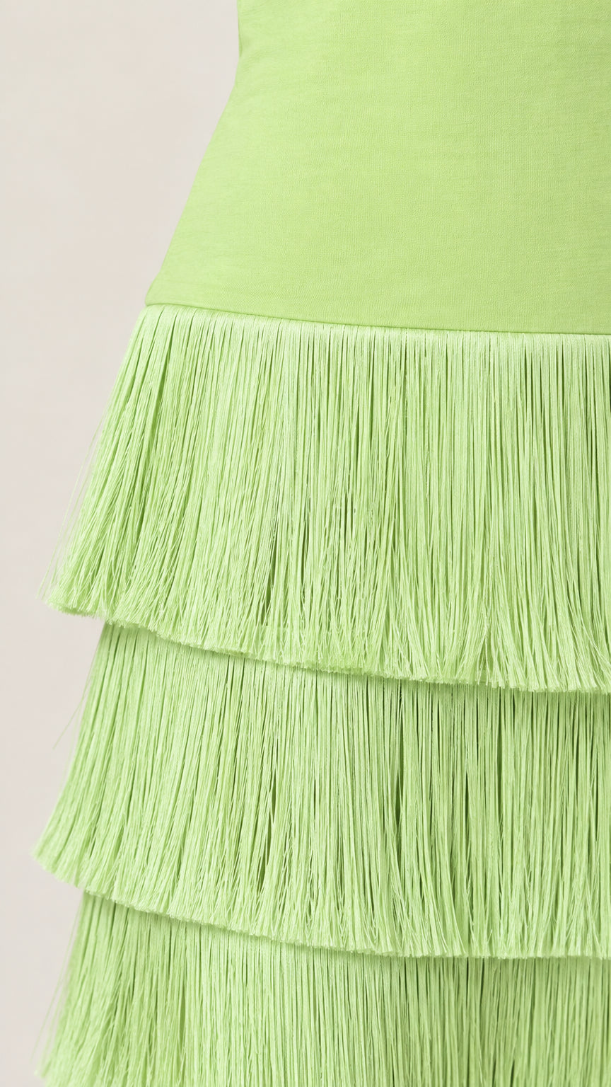 Close-up detail of lime green tiered fringe tassels on maxi dress