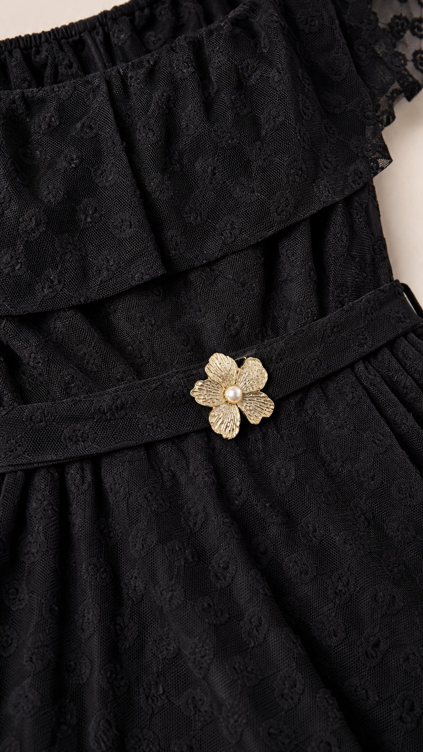 Close up of textured black Swiss dot fabric and floral waist belt