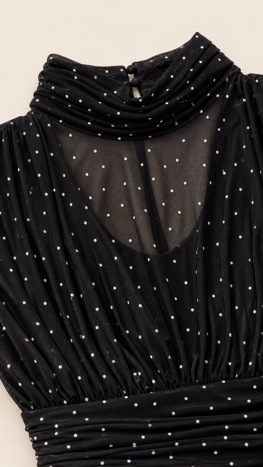 Close-up of black micro-dot sheer mesh high neck fabric and pleating