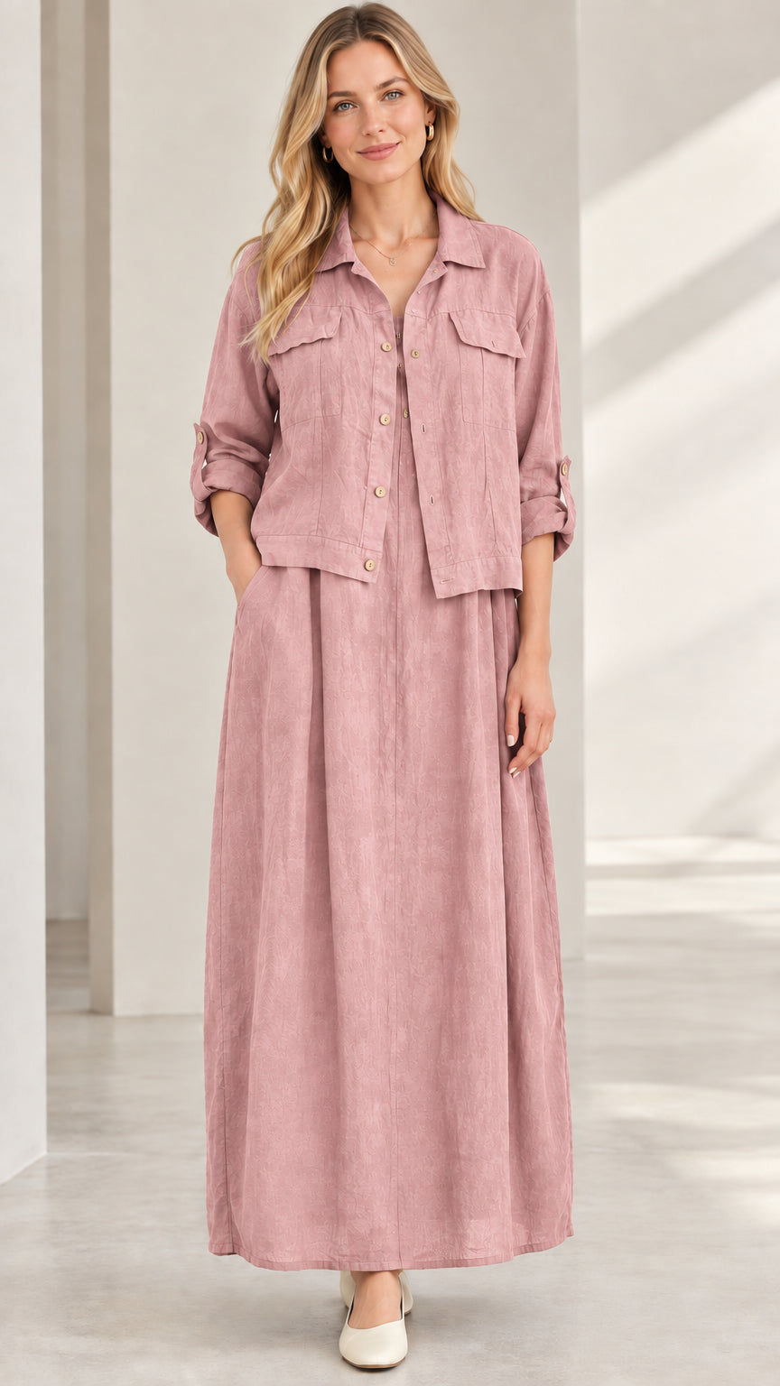Model wearing dusty pink button-up jacket and flowing maxi skirt set